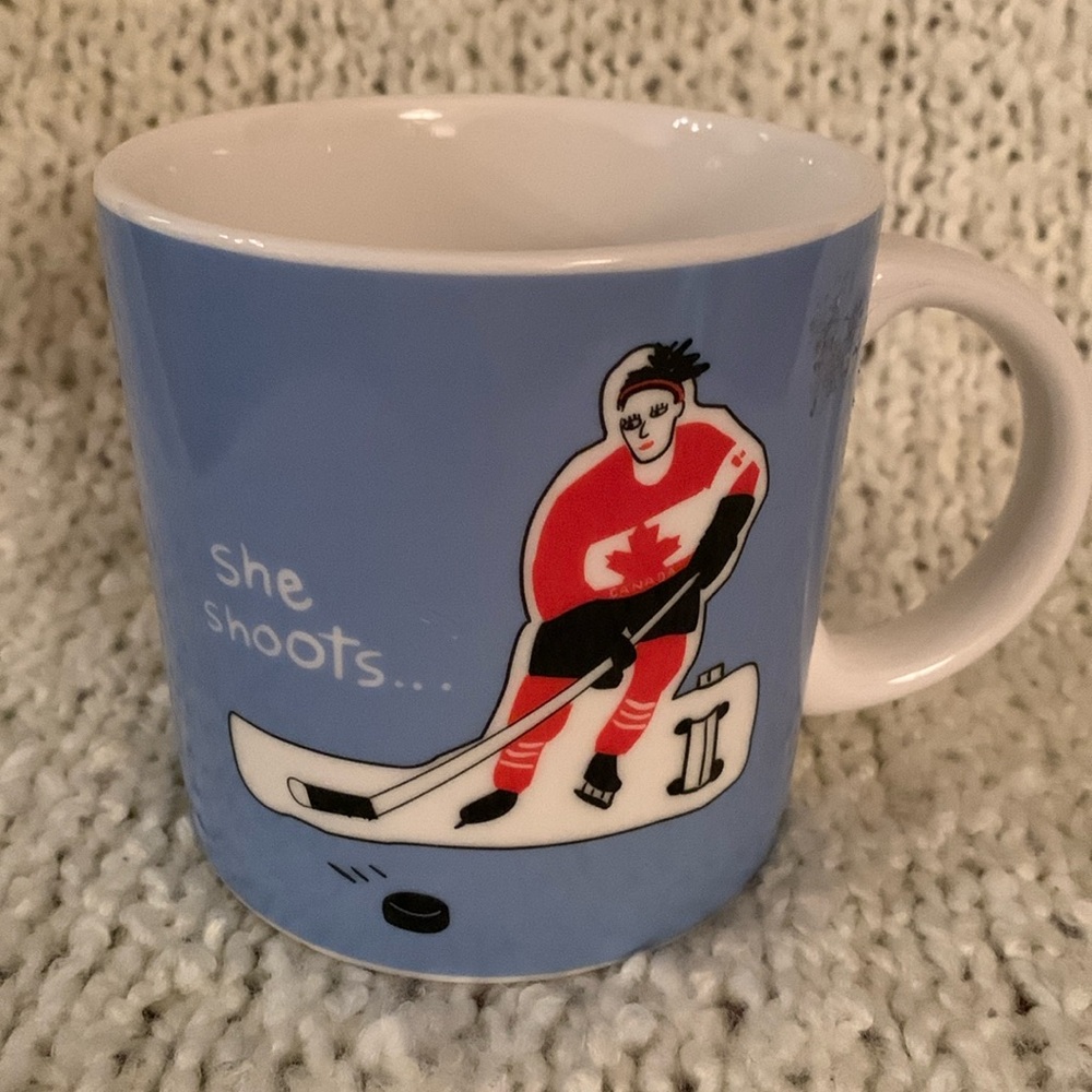 Blue hockey mug withh a female hockey player on it.